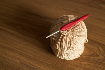 two skeins of yarn for knitting and hook on the tableの写真素材
