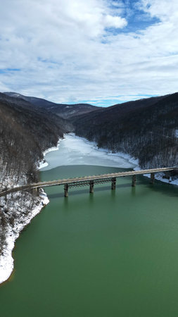 Mountain Bridge Over Thawing River in Early Spring Valley