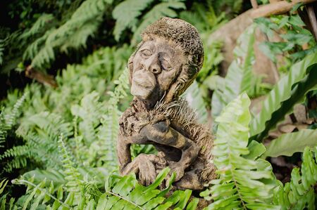 antique ancient statue covered with mossの写真素材