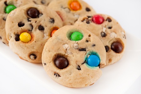 Beautiful cookies with multi-colored jelly beans on a white rectangular plateの写真素材