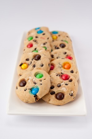 Beautiful cookies with multi-colored jelly beans on a white rectangular plate