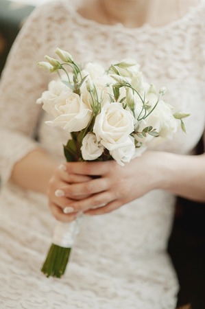 beautiful wedding bouquet of flowers in the hands of the brideの写真素材