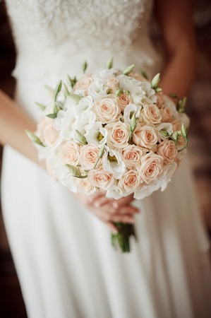 beautiful wedding bouquet of flowers in the hands of the brideの写真素材