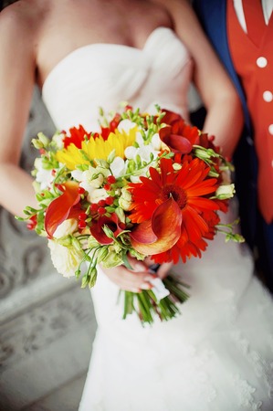 beautiful wedding bouquet of flowers in the hands of the brideの写真素材
