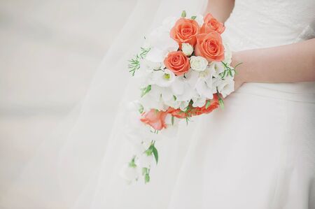 beautiful wedding bouquet of flowers in the hands of the brideの写真素材