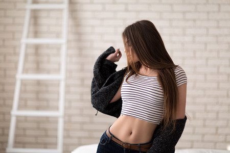 Studio portrait of a beautiful girl casual style in the bedの写真素材