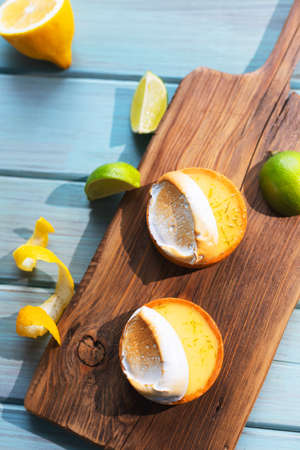 Fresh cakes on a plank with fruits on a blue backgroundの写真素材