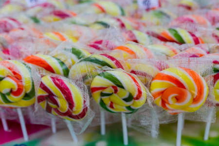 Round multicolored delicious lollipops candies, background, top view, close-upの写真素材
