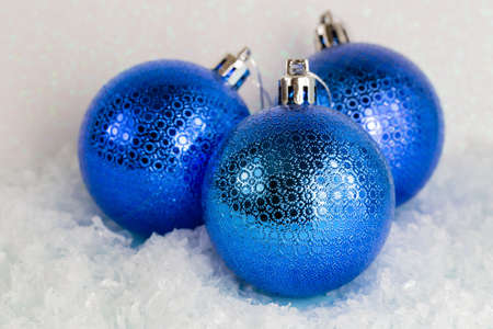 Blue Christmas balls lie on the snow, white background, front view, copy spaceの写真素材