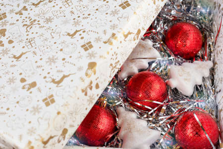 Red Christmas balls and white artificial Christmas trees on decorations with lights in a box under the lid, top view, backgroundの写真素材