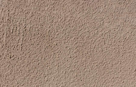 The concrete texture of a beige wall with a fur coat finish is a wonderful background for your design, copy spaceの写真素材