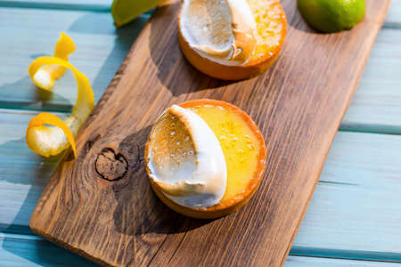 Fresh tasty cakes on a board with fruits on a blue backgroundの写真素材