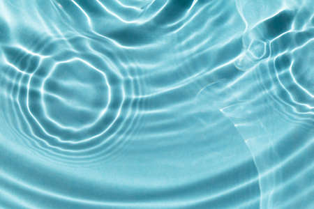 Sun glare on water waves. Light blue textured background. Close-up, selective focusの写真素材