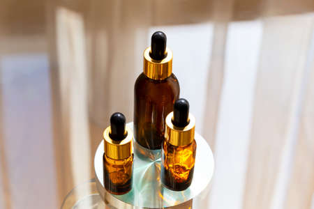 Set of brown glass dropper bottles with a pipette on a metal and glass background. Organic, natural cosmetics. Beauty, skin care. Spa products. Close up, copy space. Selective focusの写真素材