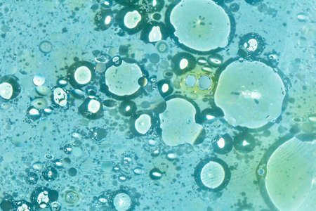 Lots of oily yellow spots on the water, circles in the water on a light blue background, bubbles,...