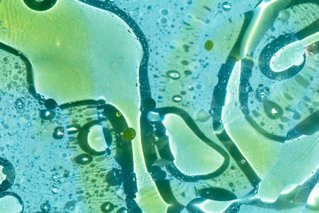 Lots of big yellow oil slicks on blue water. Textured background for any design. Space, magic,...