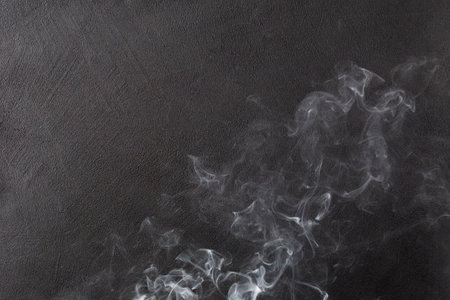 White smoke on black background rises up. Background with copy spaceの写真素材