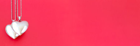 Two pendants on a chain in the form of a heart on a red background. Banner for Valentine's Day. Flat...