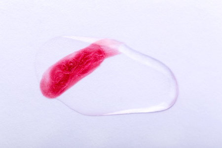 Cosmetic smear of red nail polish or lip gloss, lipstick under a transparent liquid. Check for...