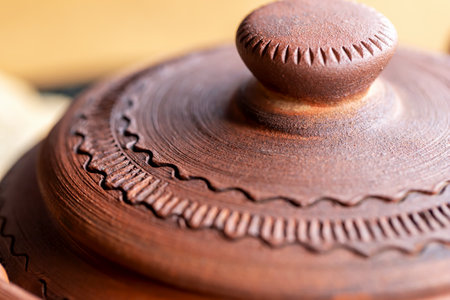 Clay jug with a lid top view close-up. Serving soup in a restaurant. Clay, ceramic dishes. Pottery. Selective focus, defocusの写真素材