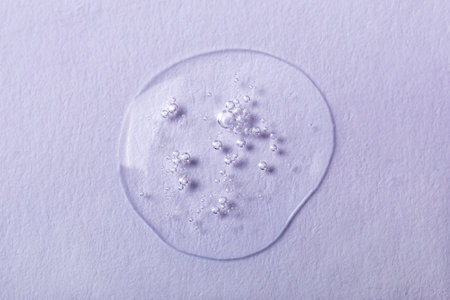 Drop of transparent liquid with bubbles on white background. Laboratory studies. Cosmetics, gel, transparent texture, lotion. Selective focus, defocusの写真素材