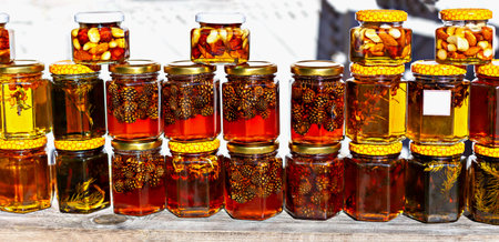 Nuts and cones, sea buckthorn and spruce in honey in glass jars. Proper nutrition and health, sweet...