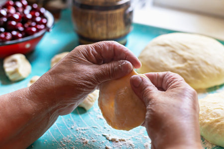 Cooking pies. Hands of skilled baker elderly expertly shaping dough for pies on colorful kitchen...