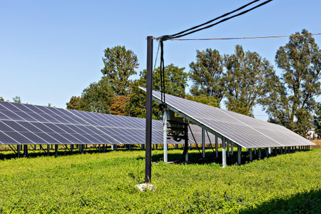 Solar energy. Solar panels positioned in lush green field, capturing sunlight under clear blue sky,...