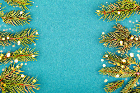 Christmas. New Year. Evergreen branches adorned with delicate snowflakes arranged on vibrant blue...