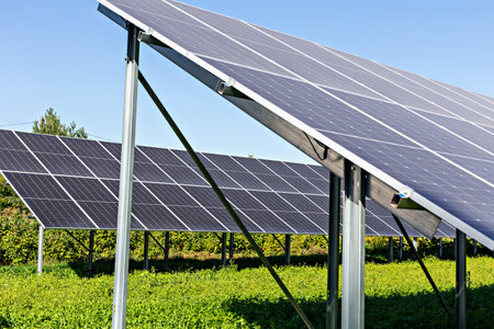 Solar energy. Solar panels positioned in lush green field, capturing sunlight under bright blue sky,...