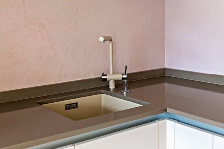 Kitchen interior. Modern kitchen sink featuring sleek faucet and stylish countertop in pastel colors, creating serene ambiance in contemporary kitchen space with clean lines and minimalistic designの写真素材