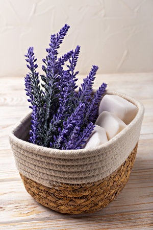Lavender soap. Beauty and health. Lavender flowers elegantly arranged in woven basket accompanied by natural soap bars, creating serene and calming ambiance, perfect for relaxation and wellness themesの写真素材