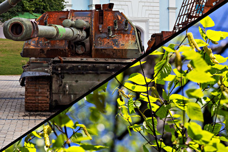 War or peace. Rusty military tank stands prominently in urban setting, contrasted by vibrant green leaves spring blooming birch, showcasing contrast between death and lifeの写真素材