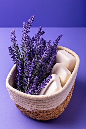 Lavender soap. Beauty and health. Lavender flowers are beautifully arranged alongside white soap bars in woven basket, creating serene and calming aesthetic against vibrant purple backgroundの写真素材