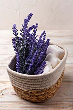 Lavender soap. Beauty and health. Lavender flowers arranged in woven basket alongside white soap bars create calming atmosphere on rustic wooden table, enhancing serene and natural aesthetic of sceneの写真素材