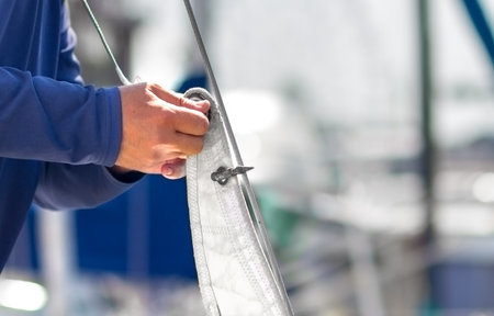 A sailor puts on sails on a yacht for a sea trip. Preparing the ship for the cruise.の写真素材