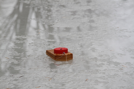 Child's homemade wood boat floating on iceの写真素材