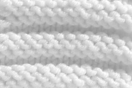 Texture pattern knitting with acrylic thread. Manual work with knitting needles, white background of wool.の写真素材