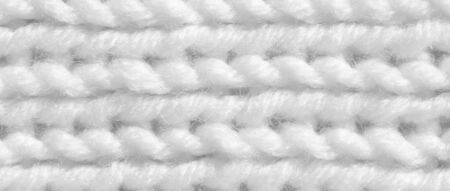 Texture pattern knitting with acrylic thread. Manual work with knitting needles, white background of...