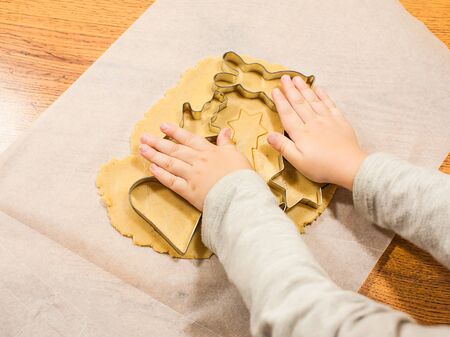 making gingerbread with cookie cutters on baking paper