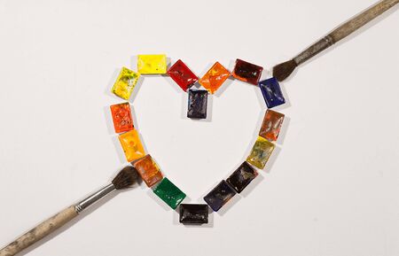 Watercolor paints as heartshape with brushesの写真素材