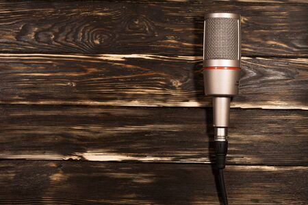 Grey microphone on wooden background.の写真素材