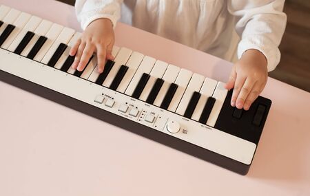 Little girls hands playing electronic piano.の写真素材