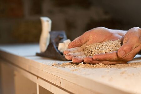 Hands holding sawdust with planeの写真素材