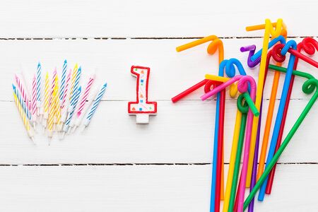 Multicolor cocktail tubes and candles for the cake on white background. Concept birthday partyの写真素材