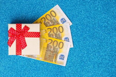 Gift box with 200 euros on sparkling blue background. Bright and festive, close upの写真素材