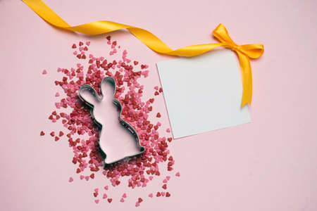 Easter postcard. Rabbit and pink decor on pink background Place for text.の写真素材
