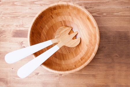 Wooden bowl and cutlery on wooden background or table. Natural serving table settingの写真素材