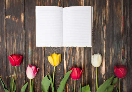 diary or notebook with spring flowers on wooden background. close upの写真素材