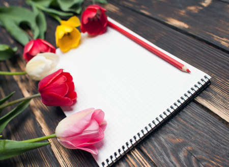 diary or notebook with spring flowers on wooden background. close upの写真素材